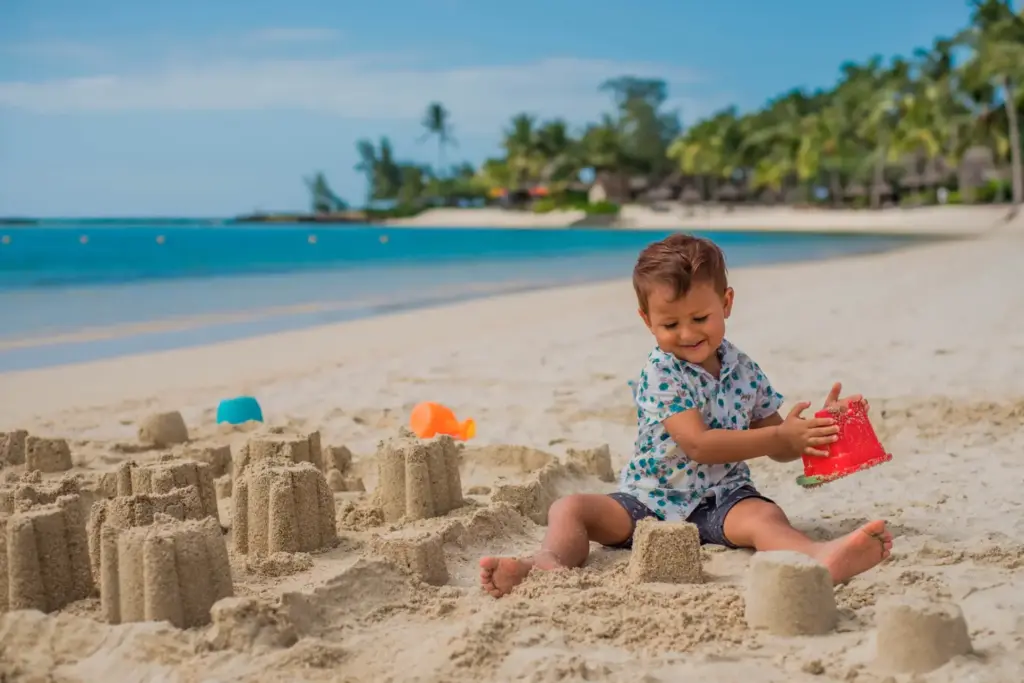 Kind spielt im Sand vor dem familienfreundlichen Hotel Constance Prince Maurice auf Mauritius, das bei Fenners Reisen gebucht werden kann