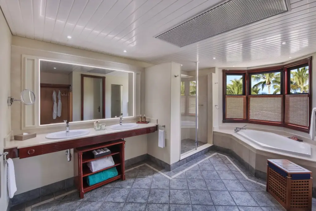 Ein großzügiges Badezimmer mit Wanne und Doppelwaschbecken erwartet Gäste in den Junior und Zen Suiten des Dinarobin Beachcomber. Buchen Sie einen Aufenthalt auf der Trauminsel Mauritius bei Fenners Reisen!