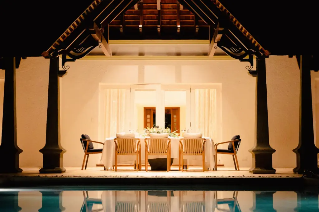 Eine lange Tafel im Abendlicht am Pool - buchen Sie einen intimen Villenurlaub auf Mauritius bei Fenners Reisen