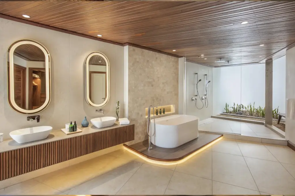 Ein großzügiges Badezimmer mit modernem Doppelwaschtisch, freistehender Wanne und riesiger, begehbarer Dusche mit Outdoor-Feeling - maßgeschneiderten Urlaub auf Mauritius für höchste Ansprüche buchen Sie bei Fenners Reisen! Katharina Fenners berät Sie individuell.