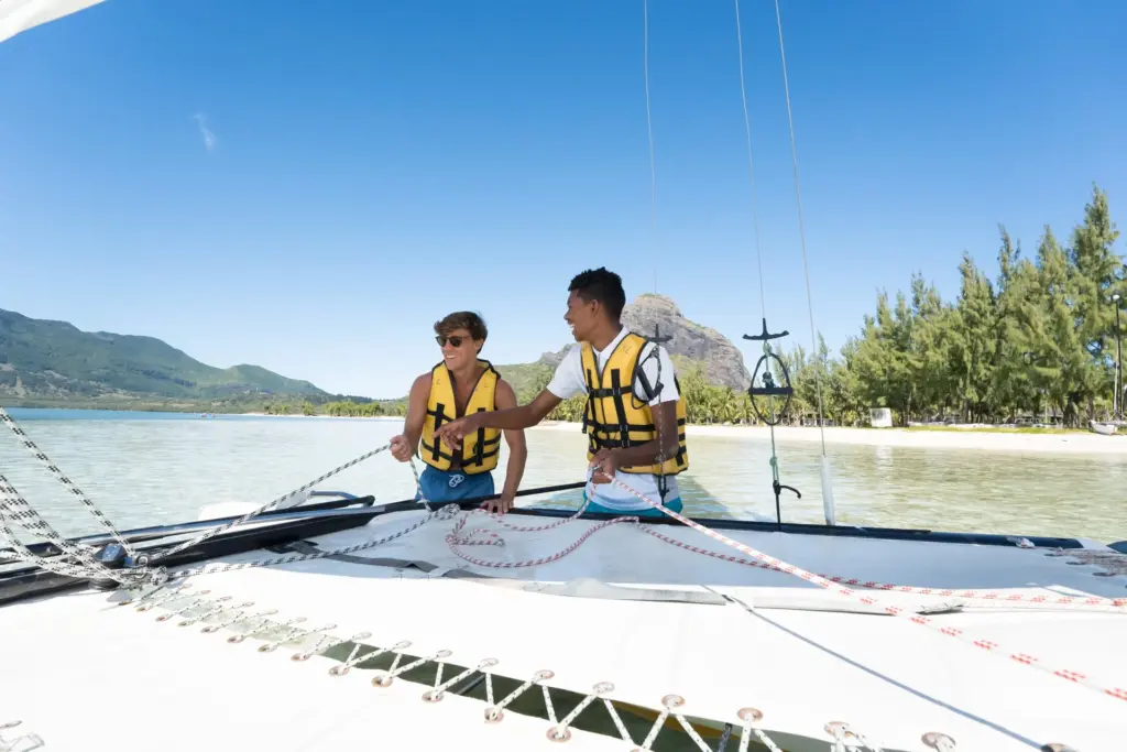 Zwei junge Männer kurz vor einem Segeltörn auf Mauritius - die Trauminsel im Indischen Ozean ist das perfekte Ziel für Wassersport-Liebhaber! Katharina Fenners berät Sie individuell und persönlich.