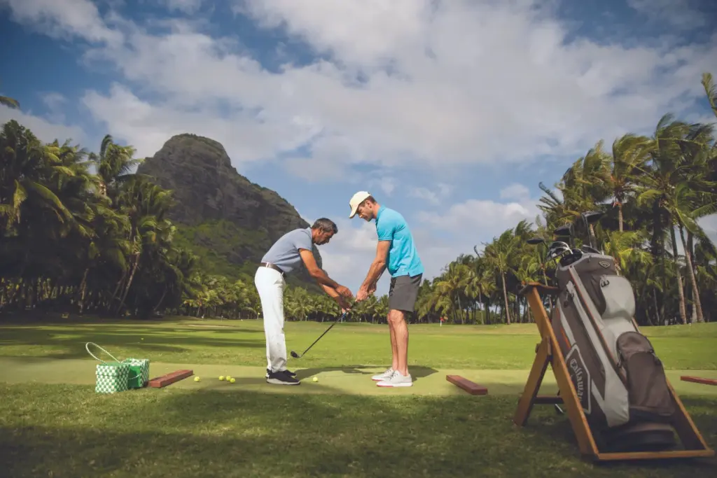 Zwei Männer spielen Golf vor der imposanten Kulisse des Le Morne Brabant auf Mauritius. Buchen Sie Ihren Golfurlaub auf Mauritius bei Fenners Reisen. Katharina Fenners kennt die besten Plätze auf der Insel!