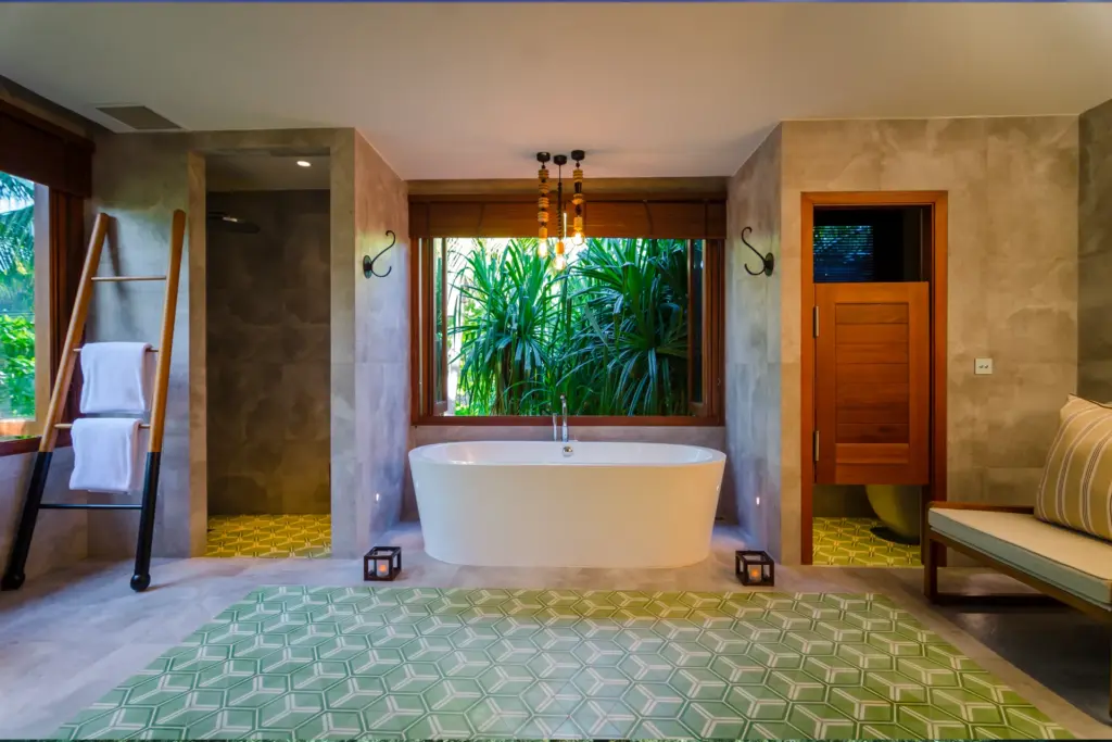 Ausgesprochen großzügig ist das Badezimmer mit freistehender Wanne dieser Treetop Pool Villa des Amilla Maldives, buchbar bei Fenners Reisen.