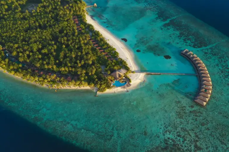 Blick aus der Luft auf die tropisch begrünte Insel Filitheyo im nahezu unberührten Faafu Atoll. Buchen Sie eine unvergessliche Auszeit auf den Malediven bei Fenners Reisen!