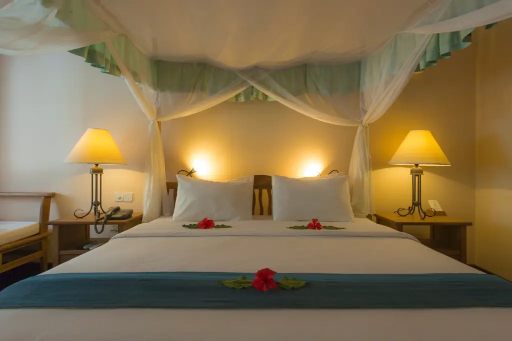 Ein mit Blüten verziertes Doppelbett in einer Superior Villa des Filitheyo Island Resorts, das bei Fenners Reisen gebucht werden kann