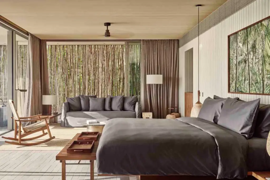 Gedeckte Farben, trendige Möbel: Schlafzimmer einer Beach Pool Villa in einem maledivischen Luxusresort. Sie sind auf der Suche nach dem perfekten Hotel für Ihren Maledivenurlaub? Katharina Fenners berät Sie individuell!