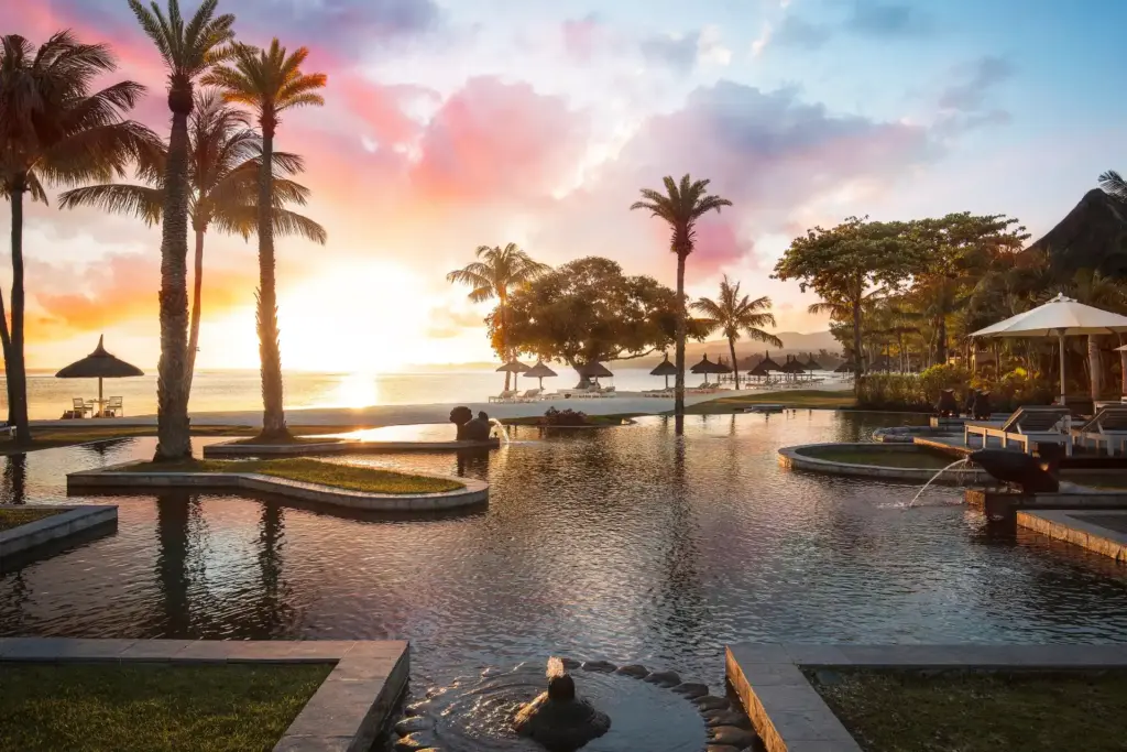 Ein stimmungsvoller Sonnenuntergang über dem Hauptpool des Shanti Maurice Resort & Spa. Der Aufenthalt kann bei Fenners Reisen gebucht werden.