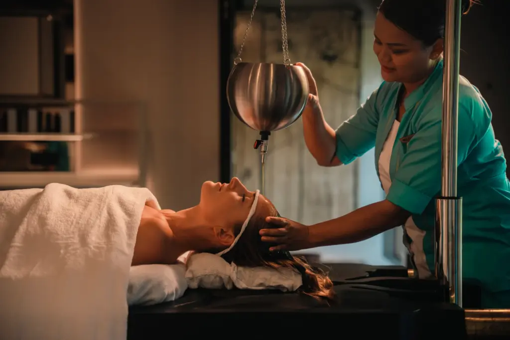 Eine Frau genießt die Behandlung im Eveylaa Wellbeing Spa-Bereich des Velaa Private Island. Buchen Sie luxuriöse Entspannung auf den Malediven bei Fenners Reisen!