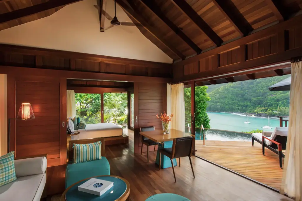 Blick in das Innere einer Hillside Villa - durch die bodentiefen Fenster schweift der Blick weit über die Bucht und den Indischen Ozean. Sie sind auf der Suche nach dem perfekten Hotel für Ihren individuellen Seychellen Urlaub? Katharina Fenners berät Sie individuell!
