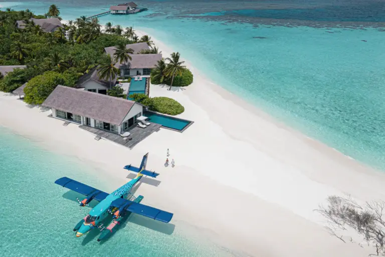 Blick aus der Luft auf ein ikonisches Wasserflugzeug, das halb im türkisen Ozean, halb auf dem puderweißen Sand einer maledivischen Privatinsel gelandet ist. Die Trauminsel Voavah auf den Malediven ist buchbar für exklusive Hochzeitsgesellschaften, intime Familienurlaube und ultraluxuriöse Auszeiten zu zweit. Katharina Fenners berät Sie individuell und organisiert den maßgeschneiderten Aufenthalt!