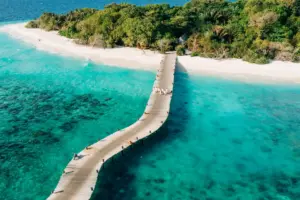 Ein langer Steg führt auf die traumhafte Insel Kunfunadhoo Island, auf der das ultraluxuriöse Soneva Fushi Resort liegt, das bei Fenners Reisen gebucht werden kann.