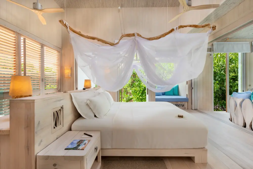 Rückzugsoase mit Flair: So präsentiert sich das Schlafzimmer eines Beach Hideaways im Soneva Jani Resort, buchbar bei Fenners Reisen