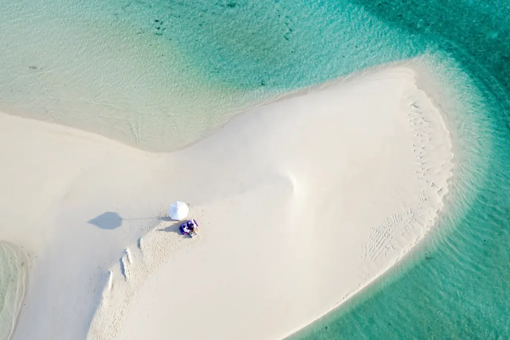 Puderweiß und absolut einsam: eine Sandbank auf den Malediven von oben gesehen. Sie planen eine Luxusreise auf die Malediven? Katharina Fenners kennt die besten Sandbänke, Korallenriffs und Resorts und berät Sie individuell!