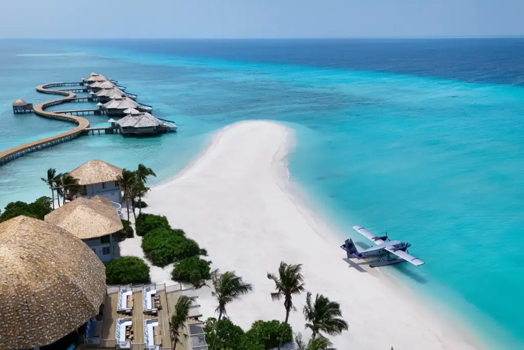 Ein Privatjet wartet an einem absolut einsamen Traumstrand, im Hintergrund reihen sich wenige exklusive Wasservillen wie eine Perlenschnur im türkisen Indischen Ozean - buchen Sie einen unvergesslichen Luxusurlaub auf den Malediven bei den Trauminsel-Spezialisten von Fenners Reisen