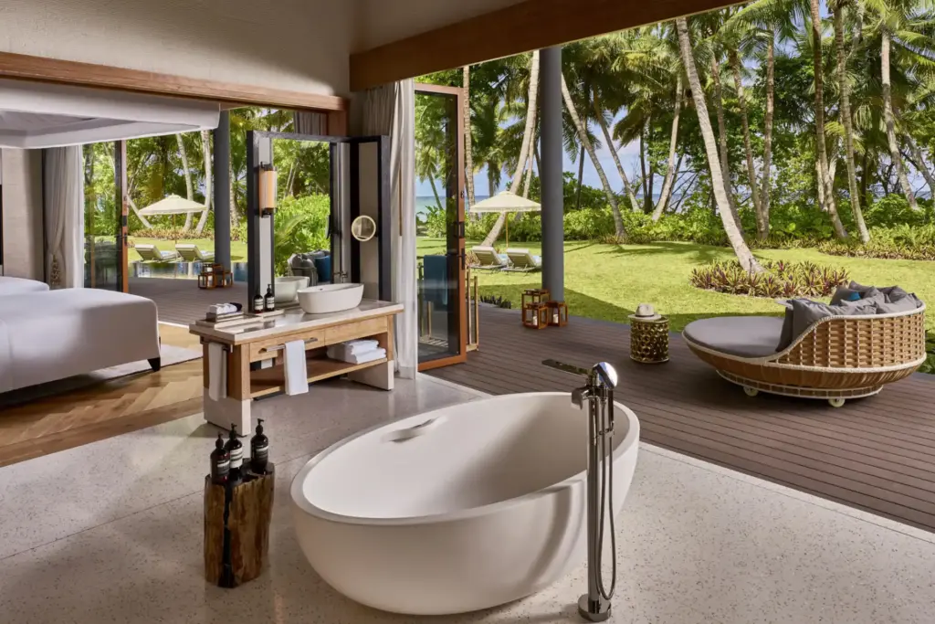 Blick auf die freistehende Wanne im Bad der Blacktip Villa auf den Seychellen - fließend schweift der Blick ins Schlafzimmer, die weitläufige Terrasse bis hin zum Meer. Ein architektonisches Meisterstück auf den Seychellen, buchbar für Ihren maßgeschneiderten Seychellen Urlaub bei Fenners Reisen!