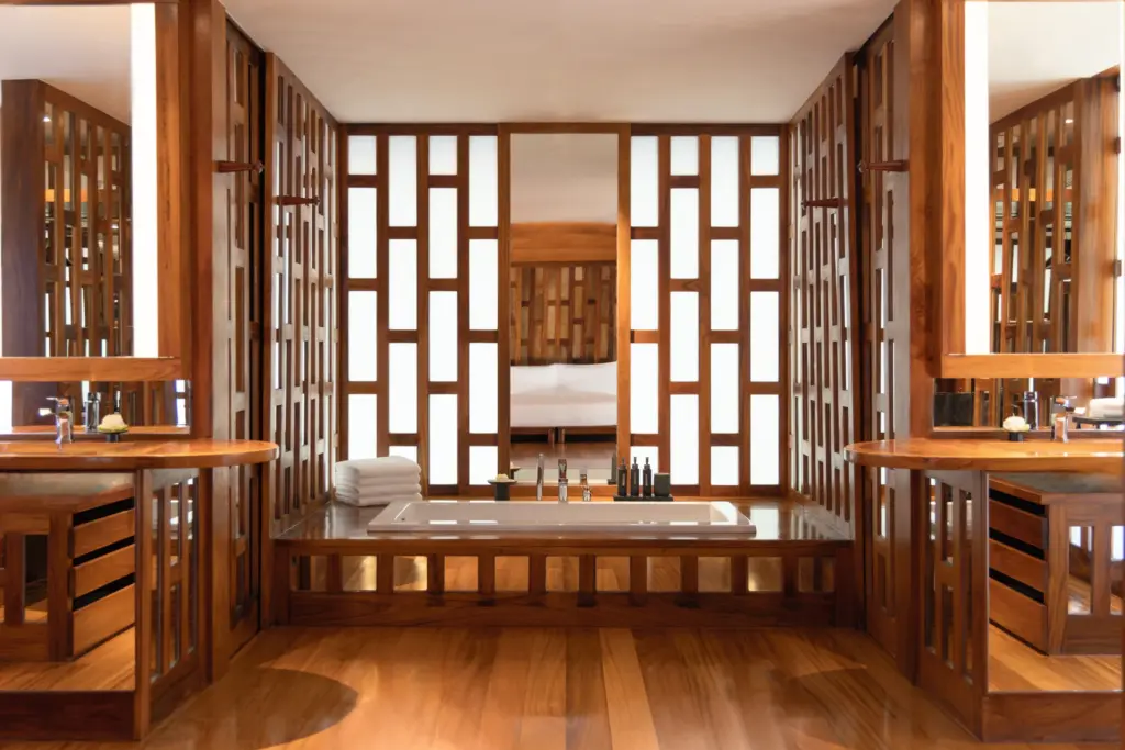 Das luxuriöse Schlafzimmer eines Ocean Pool Pavillons auf Thailand. Von der großzügigen, mit Holz umfassten Badewanne schweift der Blick ins offene Schlafzimmer. Sie suchen eine gehobene Unterkunft für eine Thailand Luxusreise? Katharina Fenners berät Sie persönlich und gestaltet Ihren maßgeschneiderten Aufenthalt!