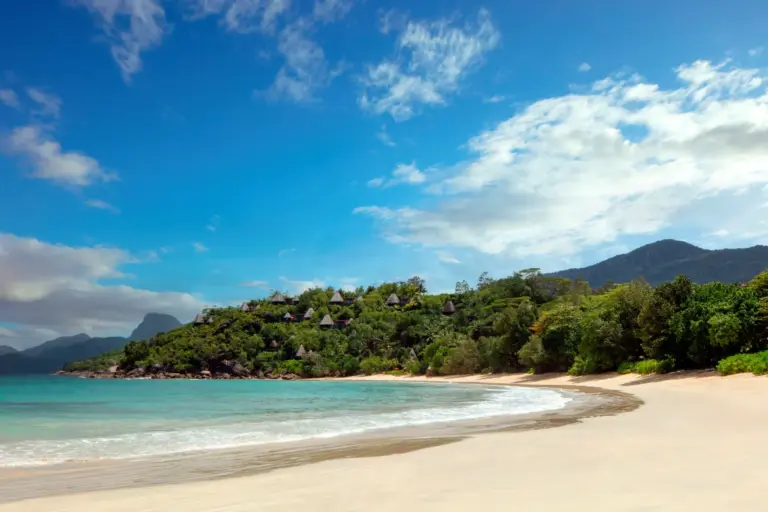 Der lange Sandstrand unterhalb des intimen Anantara Maia Seychelles Villas verführt mit betörend weichem Sand. Buchen Sie einen exklusiven Seychellen Luxusurlaub bei Fenners Reisen!