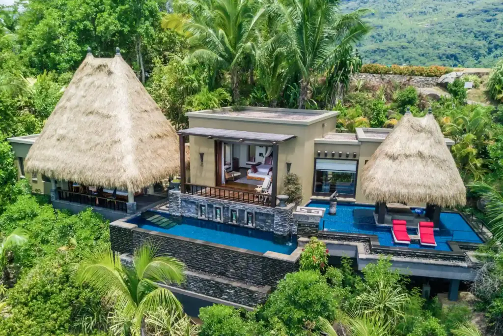 Diese Ocean View Pool Villa besticht mit doppeltem Infinity Pool und tropischer Kulisse am Hang - buchbar für einen intimen Seychellen Urlaub bei Fenners Reisen