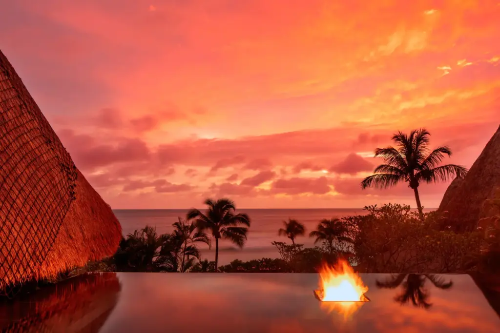 Spektakulärer Sonnenuntergang, gesehen vom Infinity Pool einer intimen Villa des exklusiven Anantara Maia Seychelles. Buchen Sie einen unvergesslichen Aufenthalt bei Fenners Reisen!