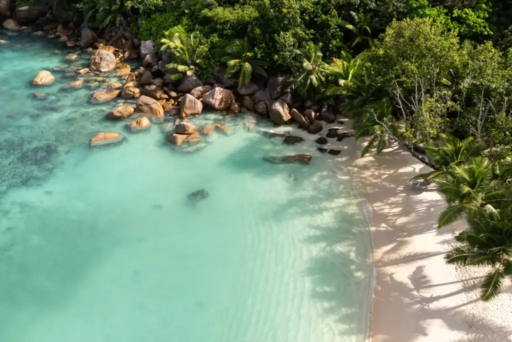Ikonische Felsen im türkis schimmernden Indischen Ozean vor einem strahlend weißen Sandstrand, umrahmt von tropischer Vegetation - so paradiesisch ist die Kulisse eines Seychellen Luxusurlaubs. Seychellen-Expertin Katharina Fenners berät Sie individuell!