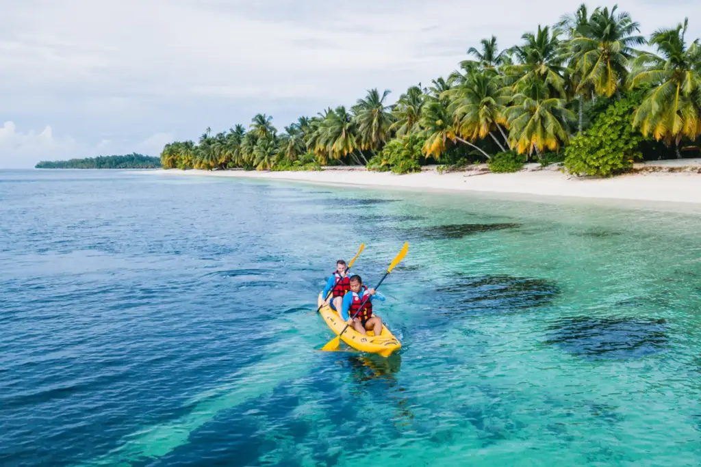 Kayakfahrer vor der Bilderbuchkulisse einer einsamen Seychelleninsel. Katharina Fenners kennt alle Trauminseln im Indischen Ozean persönlich und berät Sie zu den besten Resorts auf den Seychellen und anderswo!