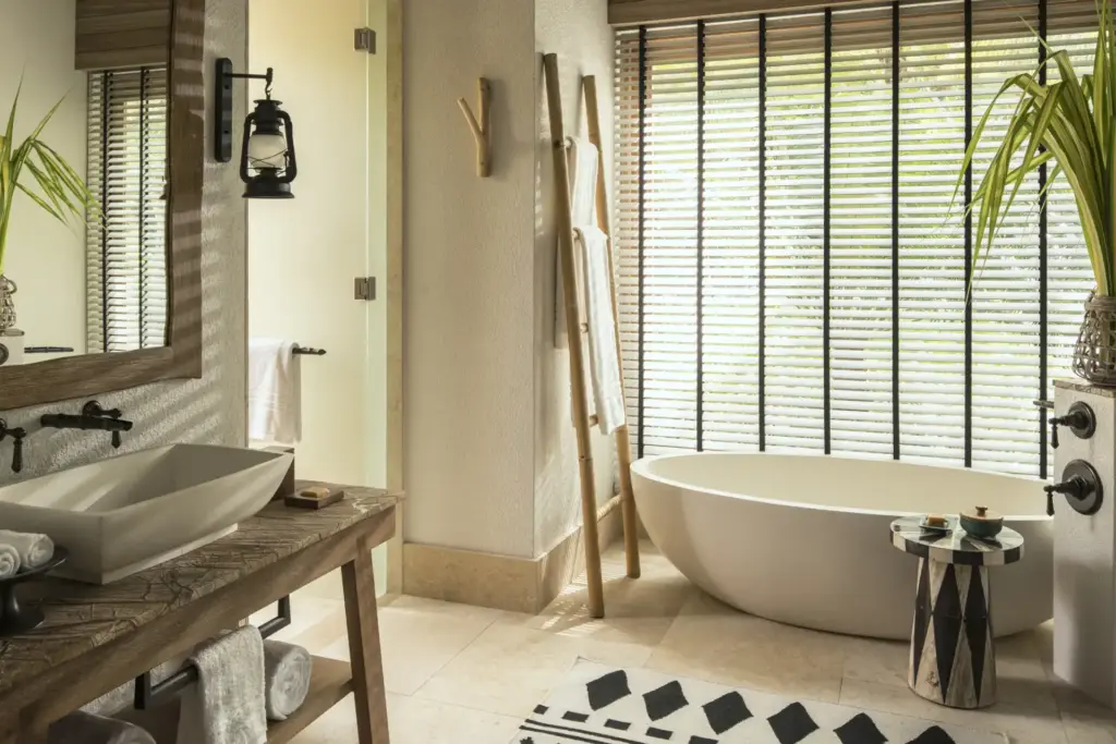 Stilvolle Details und natürliche Materialien zeichnen dieses Badezimmer mit eleganter freistehender Wanne aus - es gehört zu einer Beach Pool Villa des Four Seasons Resort Seychelles at Desroches Island, buchbar bei Fenners Reisen.