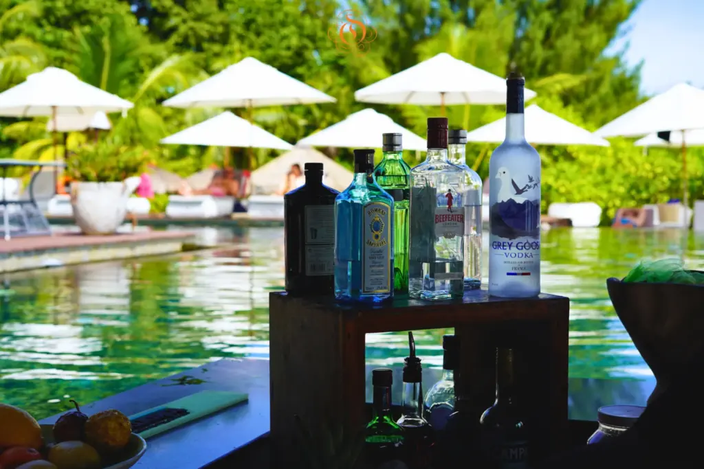 Erfrischendes und Hochprozentiges vor dem Hintergrund des Hotelpools des Le Domaine de L'Orangeraie Resort & Spa Seychelles, buchbar bei Fenners Reisen.