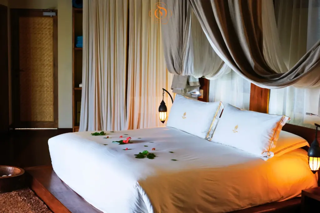 Romantisch: Ein mit Blüten geschmücktes Hotelbett auf den Seychellen. Buchen Sie Ihre Seychellen-Flitterwochen, Hochzeitsreise oder romantische Auszeit als Paar bei Fenners Reisen! Katharina Fenners kennt die besten Resorts und Hotels für intime Herzklopfmomente.