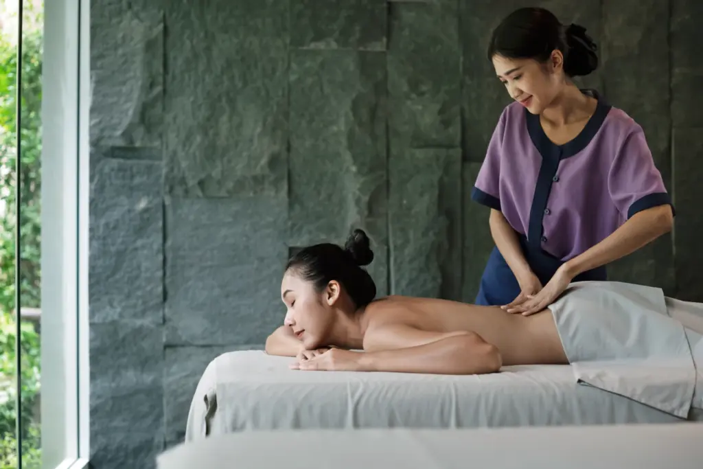 Eine Frau genießt während ihres Wellnessurlaubs in Thailand eine traditionelle Massage in stilvollendetem Setting. Katharina Fenners hat sich auf Wellness- und Gesundheitsurlaube unter anderem in Thailand spezialisiert und organisiert Ihren maßgeschneiderten Aufenthalt in den besten Hotels!