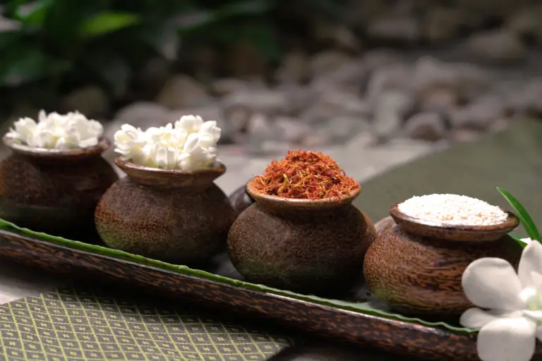 In vier Schälchen sind verschiedene Kräuter angerichtet, verziert mit Blüten - ganzheitliche Anwendungen und Behandlungen erwarten Sie im Rahmen eines Luxus-Wellnessurlaubs im Chiva Som Hua Hin Resort, buchbar bei Fenners Reisen.