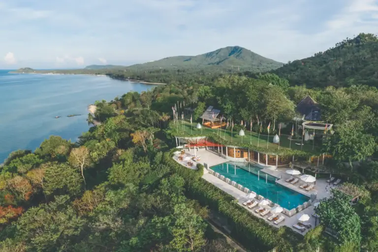 Blick über die tropische Hügellandschaft und das Meer rund um das preisgekrönte Kamalaya Koh Samui Wellness Sanctuary & Holistic Spa, buchbar für Ihre ganzheitliche Wellness- oder Gesundheitsreise nach Thailand bei Fenners Reisen!