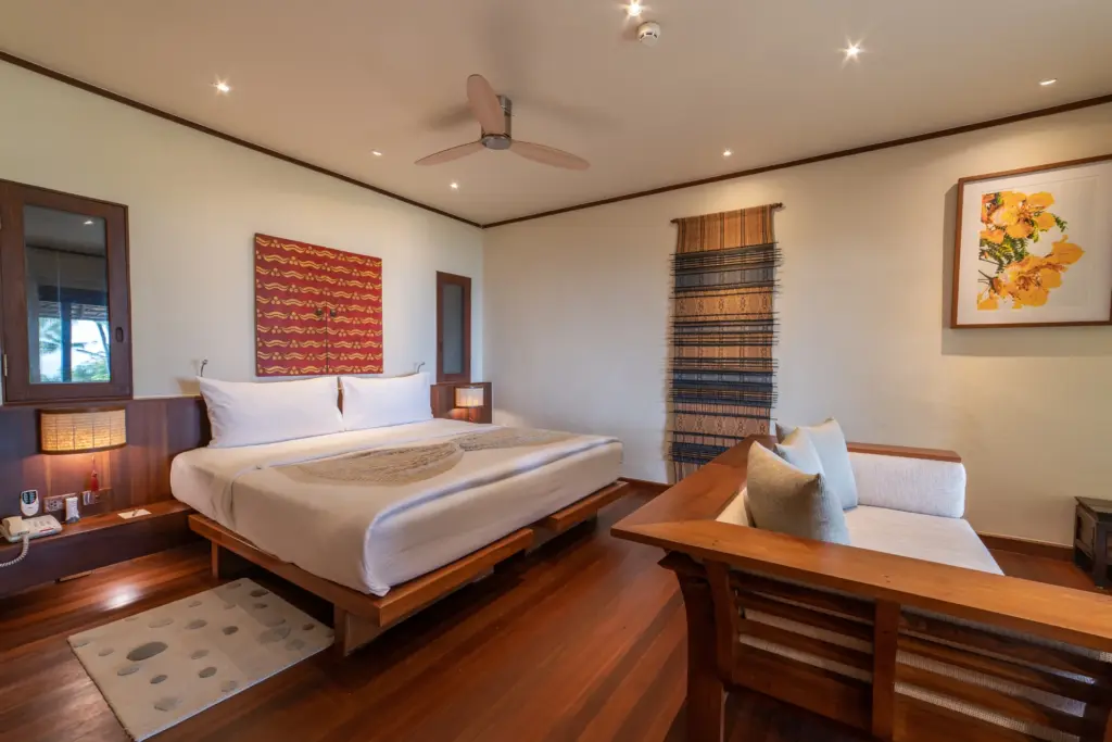 Viel Holz und natürliches Dekor prägen dieses Schlafzimmer einer Suite mit Meerblick in einem preisgekrönten thailändischen Wellnesshotel. Sie planen einen Wellnessurlaub in Thailand? Katharina Fenners hat sich auf das Theme Wellness- und Gesundheitsurlaube spezialisiert und berät Sie individuell.