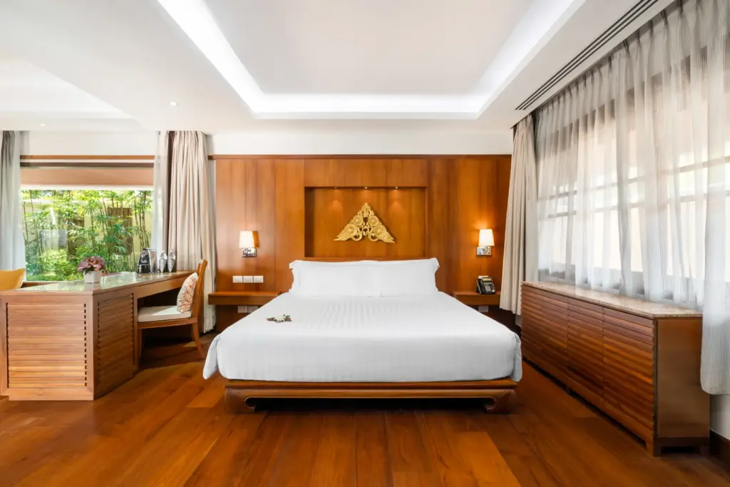 Edles Interior und viel Holz prägen dieses weitläufige Schlafzimmer einer Deluxe Pool Villa des Santiburi Koh Samui, das bei Fenners Reisen für Ihre Luxusreise nach Thailand gebucht werden kann