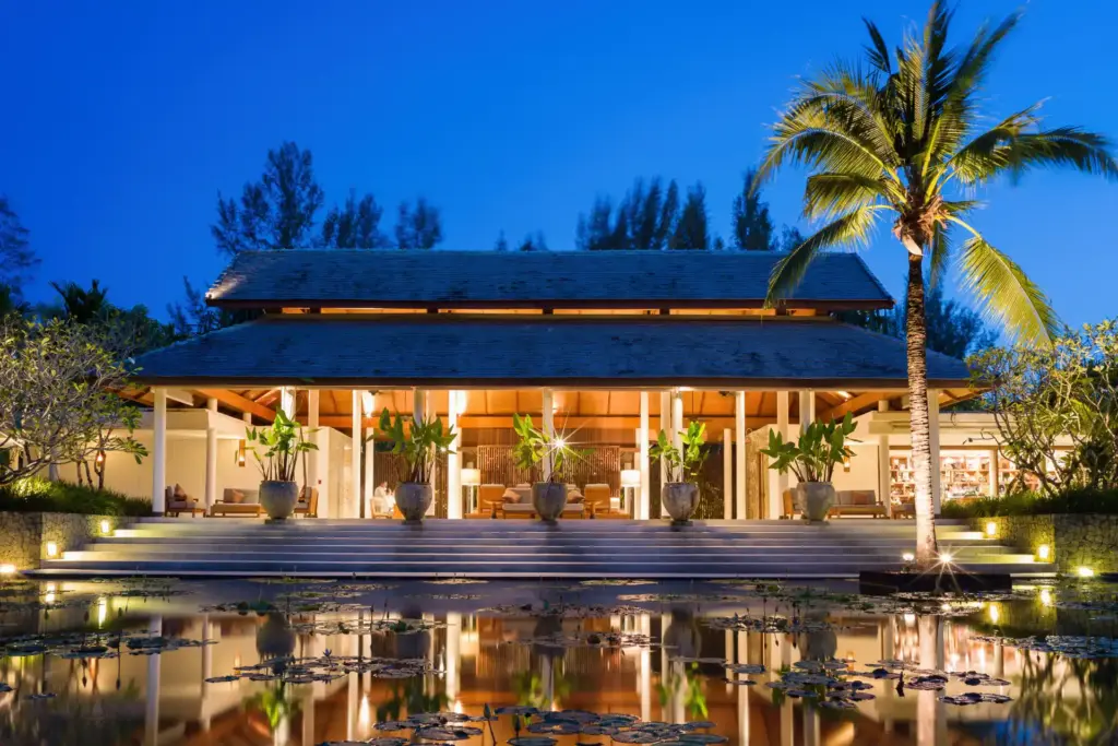 Die festlich beleuchtete Lobby des edlen The Sarojin Khao Lak Resort bei Nacht. Buchen Sie eine romantische Thailandreise bei Fenners Reisen! Katharina Fenners kennt die besten Boutique-Hotels und berät Sie individuell.