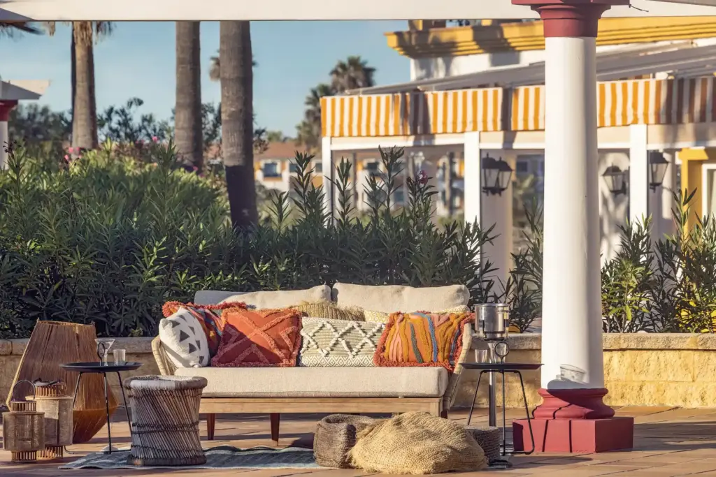 Stilecht andalusisch - ein Sofa mit bunt bestickten Kissen lädt im Aldiana Club Andalusien zum Entspannen im Freien ein. Katharina Fenners organisiert Ihren maßgeschneiderten Aufenthalt! Auch individuelle Reisekombinationen sind möglich.