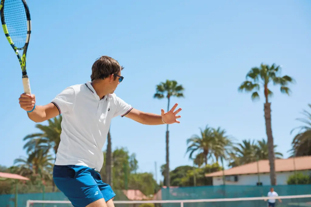 Ein Tennisspieler zwischen Palmen - wer auf der Suche nach einem aktiven, und doch erholsamen Urlaub ist, findet im gehobenen Clubresort, was er braucht. Katharina Fenners kennt die besten Resorts weltweit und berät Sie individuell!