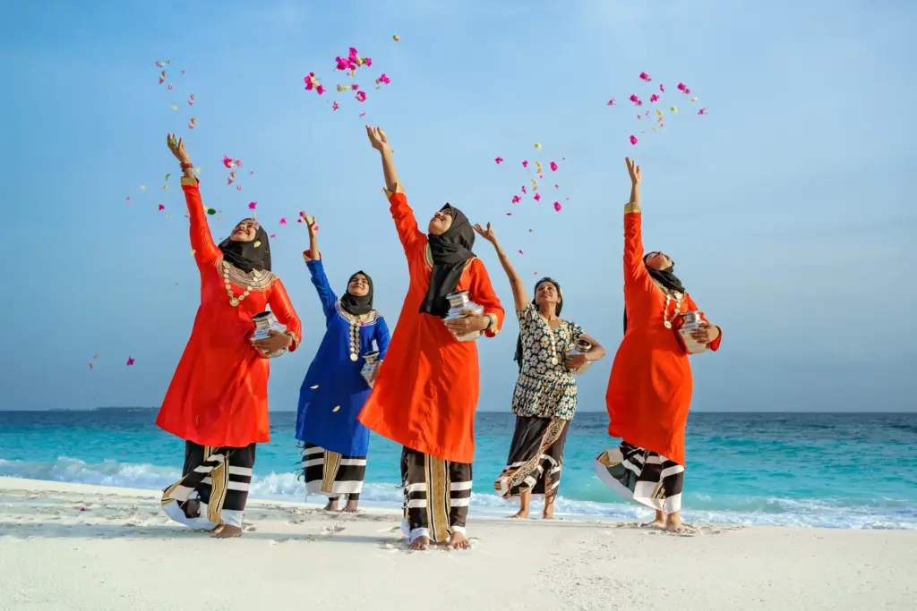 Traditionell gekleidete Frauen führen einen maledivischen Hochzeitstanz auf. Die Malediven sind ein Traumziel für Hochzeitsreisen und Trauungen, individuell buchbar bei Fenners Reisen!