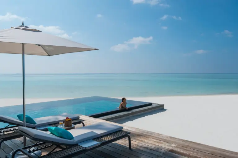 Ein Gast genießt die besondere Exklusivität im eigenen Infinity Pool, der Strand dahinter ist völlig einsam. Wer bei Fenners Reisen eine Privatinsel mietet, kommt in den Genuss besonderer Intimsphäre in spektakulärer Kulisse