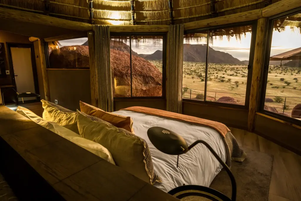 Blick aus einer Luxus-Safari-Lodge. Vom Bett gleitet der Blick weit über die Savanne, umrahmt von spektakulären Bergzügen. Sie planen eine Hochzeit in Afrika oder eine Safari-Hochzeitsreise? Katharina Fenners berät Sie individuell und organisiert Ihren maßgeschneiderten Aufenthalt.