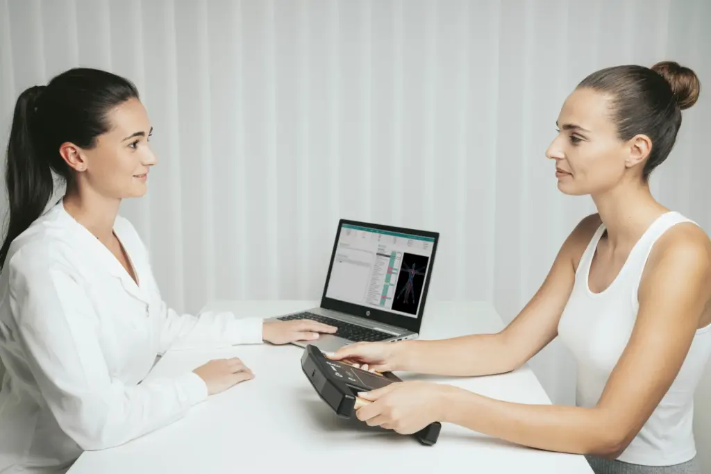 Zwei Frauen besprechen vor einem Laptop die Ergebnisse eines Screenings: So sieht die Erstuntersuchung in einem Wellnessresort oft aus. Katharina Fenners kennt die besten Gesundheitsresorts weltweit und berät Sie persönlich und individuell!