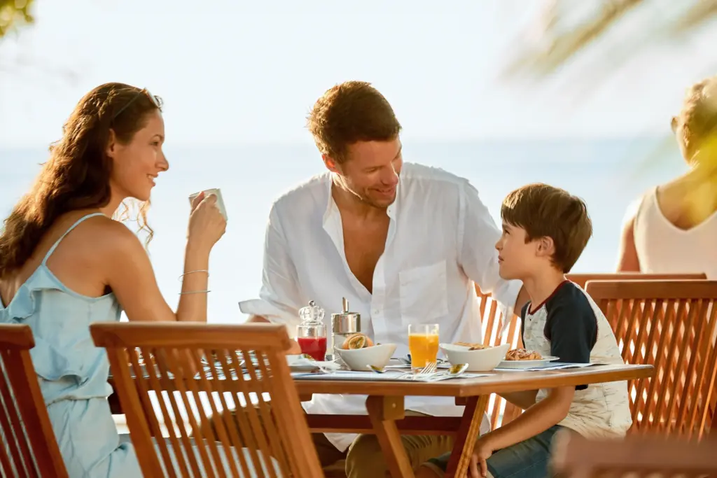 Eine Familie beim Frühstück im maledivischen Clubresort - der Aufenthalt im ROBINSON Noonu hat für Groß und Klein viel zu bieten und kann bei Fenners Reisen gebucht werden