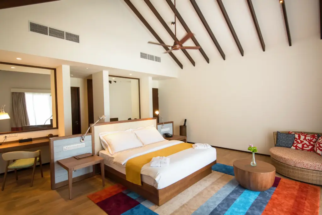 Hohe Decken und farbige Akzente prägen diese Beach Villa mit Pool, buchbar für Ihren exklusiven ROBINSON Malediven Urlaub bei Fenners Reisen