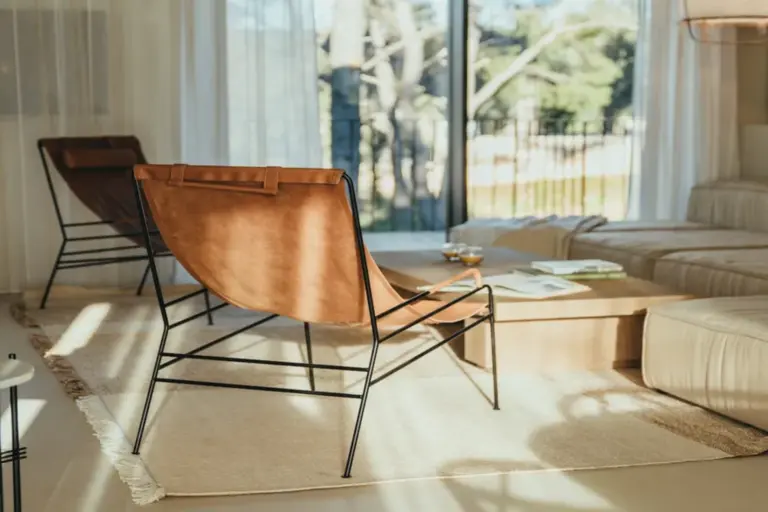 Stilvolle Designermöbel im Wohnzimmer einer Luxusvilla, aus den Fenstern schweift der Blick direkt in die Natur. Bei Fenners Reisen mieten Sie eine Villa für jede Lebenssituation - das besondere Event, eine Zusammenkunft mit Freunden und Familie oder die Workation.