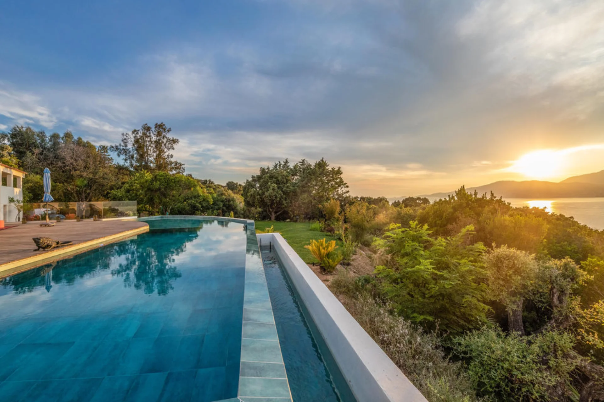 Ein Infinity-Pool mit Blick auf den flammenden Sonnenuntergang Korsikas - die Luxusvilla an der Westküste der Insel kann individuell bei Fenners Reisen gemietet werden.