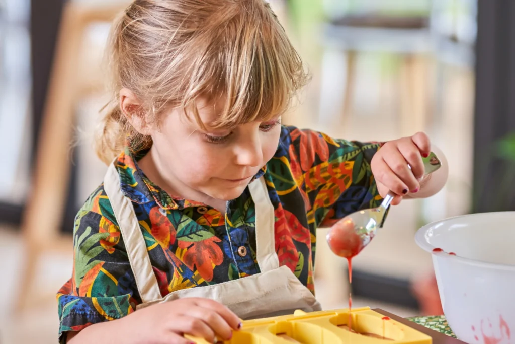 Ein Mädchen gießt selbstgemachtes Eis in eine Form. Auch Kinder und Familien sind in den LUX Hotels auf Mauritius bestens aufgehoben! Buchen Sie Ihren Familienurlaub bei Fenners Reisen!