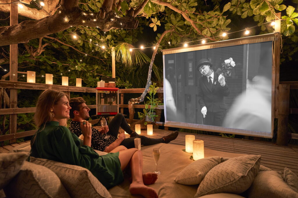 Ein Paar genießt einen Schwarz-Weiß-Film unter dem tropischen Sternenhimmel - im LUX Le Morne wartet viel Abwechslung! Katharina Fenners berät Sie individuell.