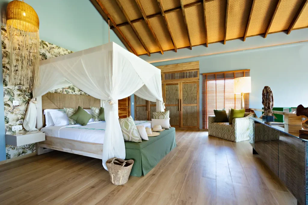 Geräumiges Schlafzimmer mit hohen Decken, Himmelbett, ruhigen Farben und modernem Interior - ein Villenschlafzimmer auf Bawe Island Zanzibar, individuell buchbar bei Fenners Reisen!