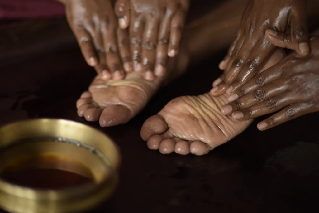 Fußmassage mit ätherischen Ölen im Kalari Rasayana Gesundheitsresort. Der Aufenthalt in dieser einzigartigen Ayurvedaklinik ist bei Fenners Reisen individuell buchbar.