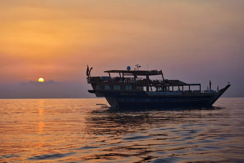 Die eigene Yacht des Six Senses Zighy Bay im Sonnenuntergang. Gäste können hier nicht nur die Bucht auf der Omanischen Halbinsel Munsandam erkunden, sondern sogar übernachten. Buchbar bei Fenners Reisen!