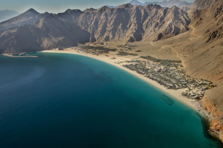 An dieser tiefblauen, von sandfarbenen Bergen umrahmten Bucht der omanischen Halbinsel Musandam liegt das Six Senses Zighy Bay. Ein Highlight Ihrer Oman Reise, gebucht bei der Expertin Katharina Fenners!